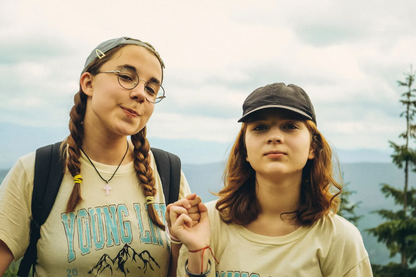 Дві дівчини у футболках Young Life на тлі гір